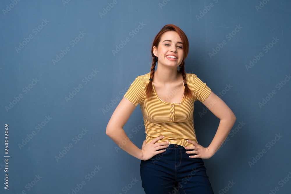 Young redhead woman over blue background happy and smiling Young redhead woman over blue background happy and smiling
