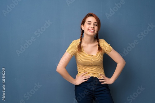 Young redhead woman over blue background happy and smiling © luismolinero