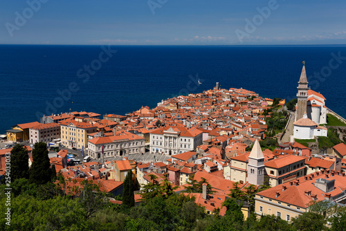 Cape Madonna at Point of Piran Slovenia on blue Adriatic Sea with Tartini Square courthouse City Hall and St George's Catholic church
