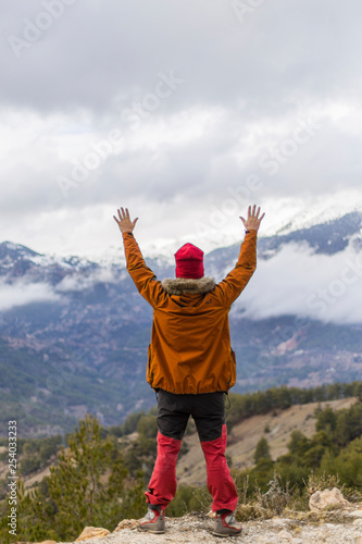 happy man with open arms raised in mountains