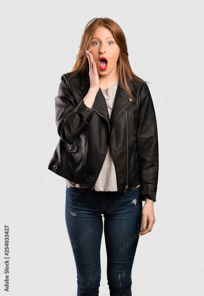 Young redhead woman with surprise and shocked facial expression over isolated grey background Young redhead woman with surprise and shocked facial expression over isolated grey background