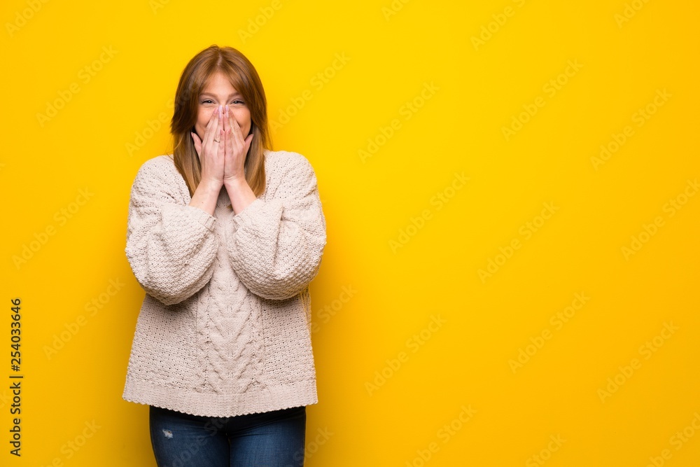 Redhead woman over yellow wall smiling a lot Redhead woman over yellow wall smiling a lot
