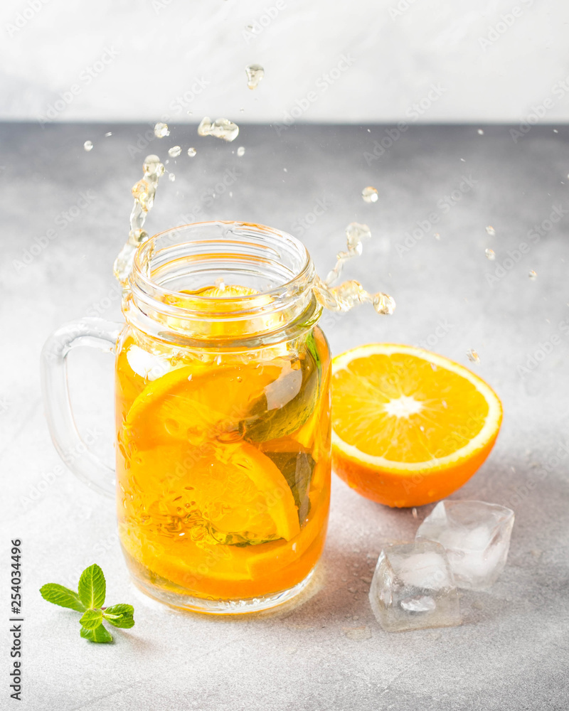 Cold tea with orange, mint and ice, sweet summer drink, refreshing lemonade, juicy cocktail. Spray, splash Cold tea with orange, mint and ice, sweet summer drink, refreshing lemonade, juicy cocktail. Spray, splash