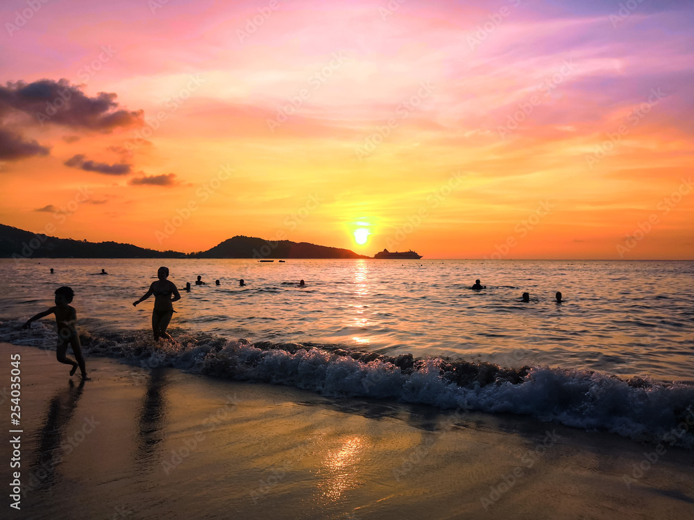 the sea at sunset and silhouettes of tourists