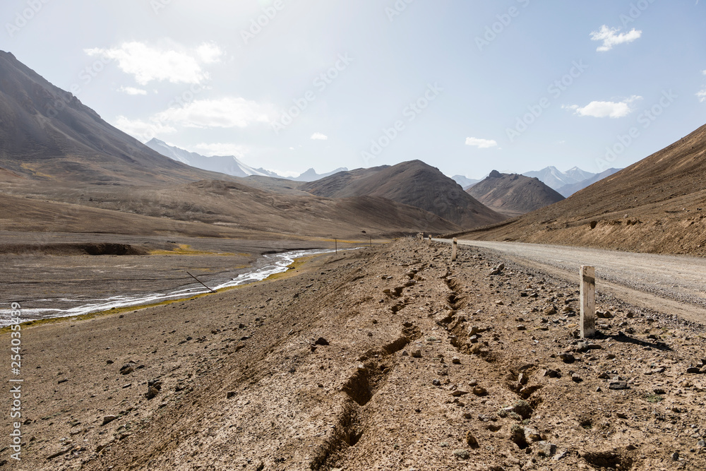 Desert landscape in the area of Ak-Baital Pass with road in the Pamir Mountains in Tajikistan