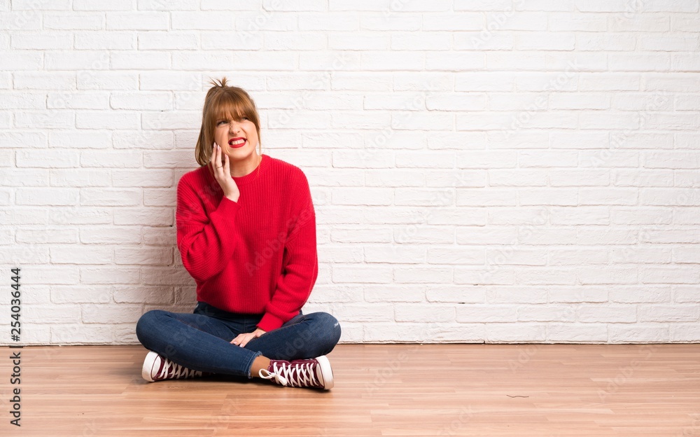 Redhead woman siting on the floor with toothache Redhead woman siting on the floor with toothache
