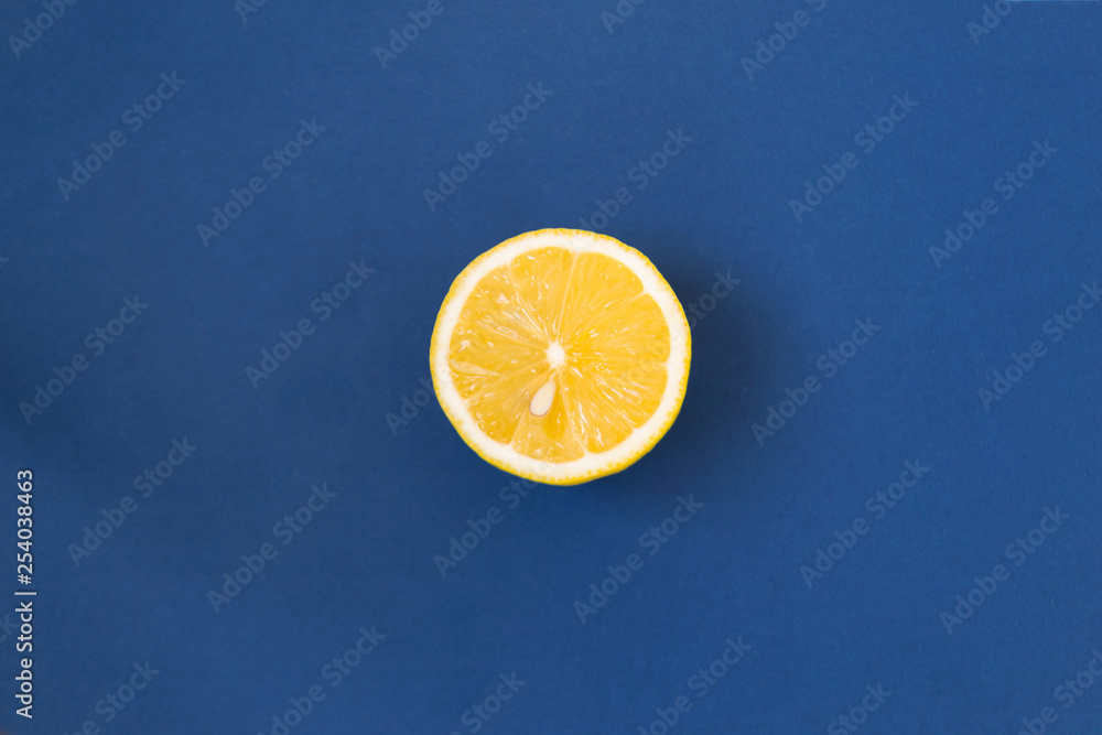 Half and whole a juicy lemon on a blue background with shadow and copy space. Ingredient for drink. Half and whole a juicy lemon on a blue background with shadow and copy space. Ingredient for drink.