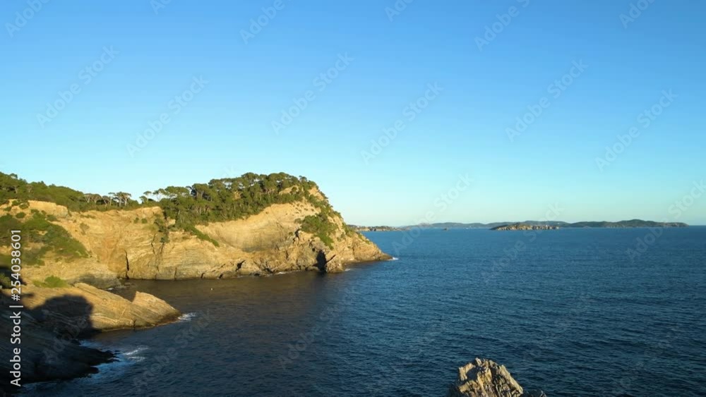 Slow zoom on steep cliff along the French riviera, lush mediterranean vegetation and sunset colors Slow zoom on steep cliff along the French riviera, lush mediterranean vegetation and sunset colors