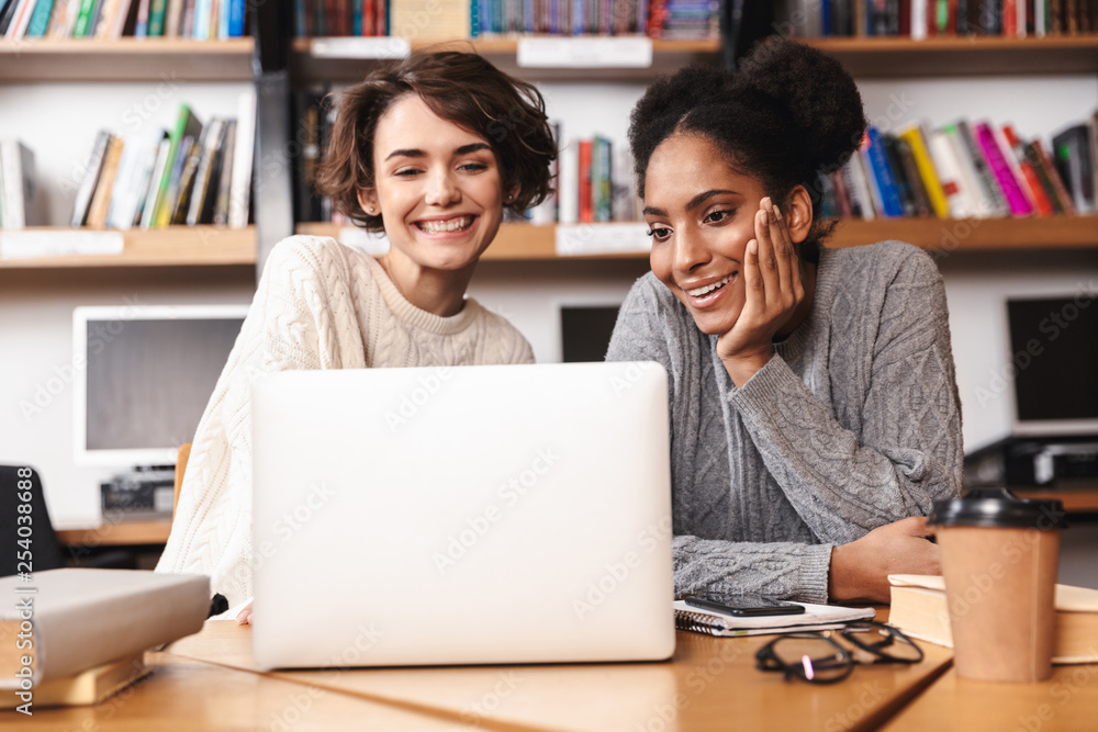 Two cheerful young girls students studying Two cheerful young girls students studying