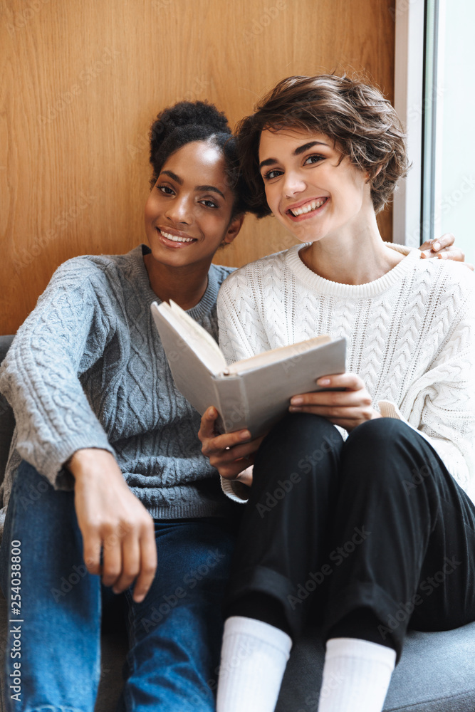 Two cheerful young girls students studying Two cheerful young girls students studying