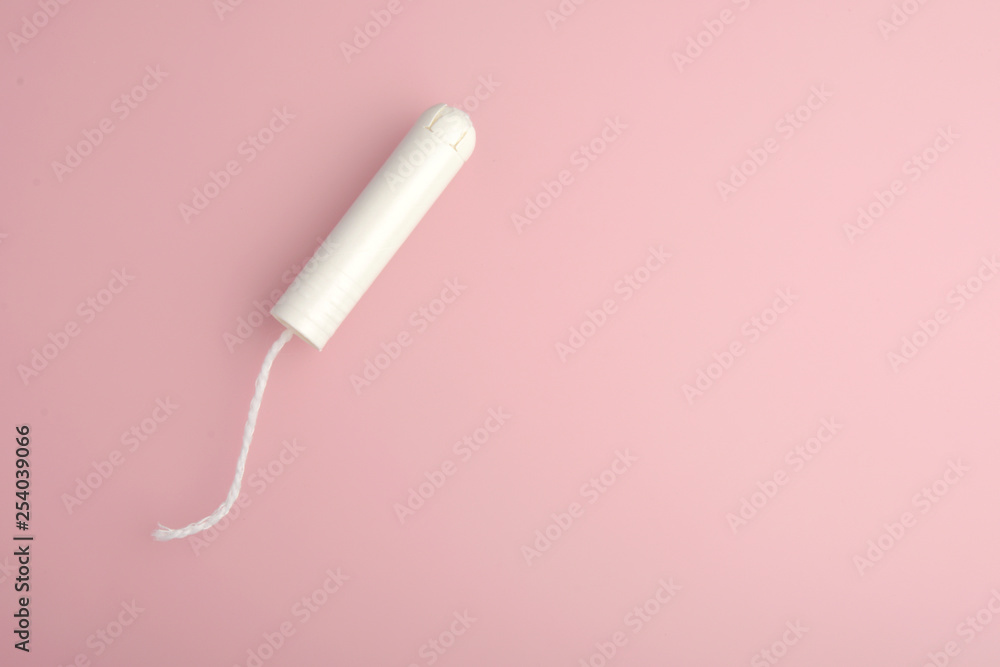 Tampon. Menstrual cycle, feminine care, menstruation and intimate products concept with internal tampon isolated on pink background with copy space . Tampon. Menstrual cycle, feminine care, menstruation and intimate products concept with internal tampon isolated on pink background with copy space .
