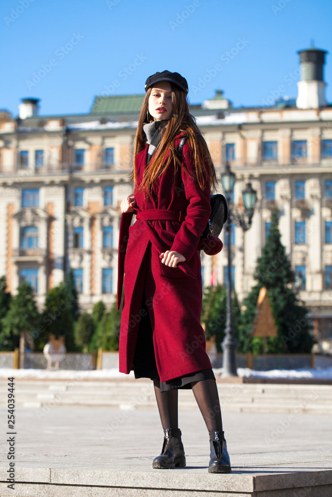 Beautiful girl in stylish in a long burgundy coat