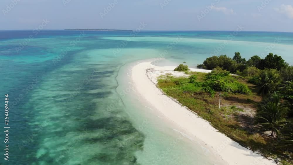 Remote and beautiful beach on a tiny island near Tawi Tawi, Philippines. Wide view of the turquoise ocean and coral reef just offshore. Majestic palm trees on an island paradise. Drone backing. Remote and beautiful beach on a tiny island near Tawi Tawi, Philippines. Wide view of the turquoise ocean and coral reef just offshore. Majestic palm trees on an island paradise. Drone backing.