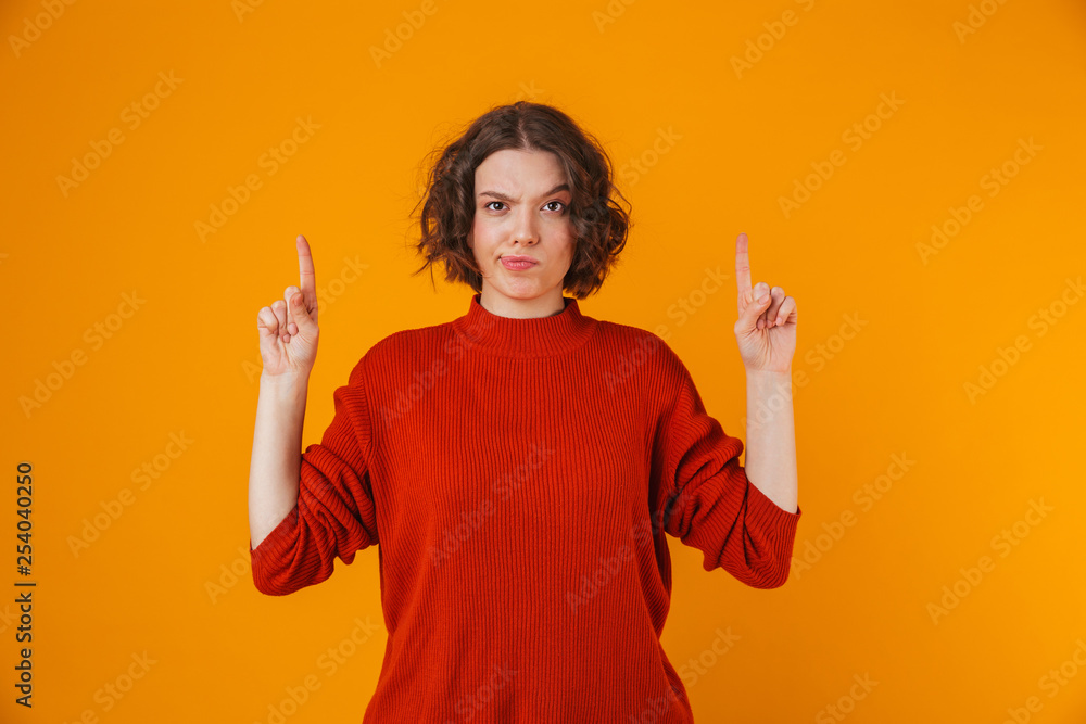 Confused young pretty woman posing isolated over yellow wall background pointing. Confused young pretty woman posing isolated over yellow wall background pointing.