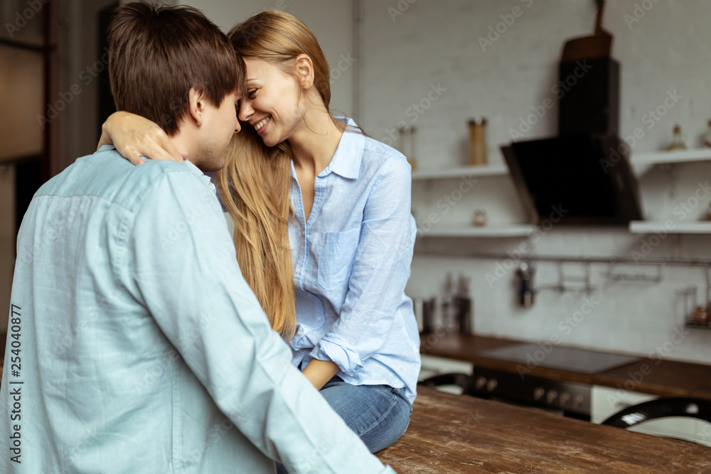 Happy hispanic couple in blue denim cloth embracing in kitchen Happy hispanic couple in blue denim cloth embracing in kitchen
