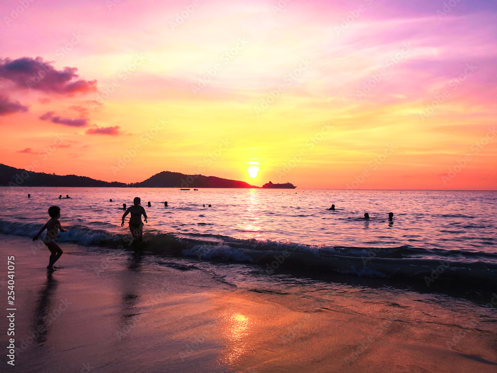 the sea at sunset and silhouettes of tourists