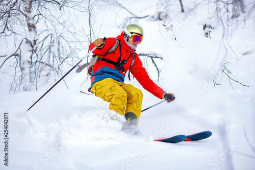 Concept extreme winter sport. Man skier high speed rides on fresh snow, dust in air