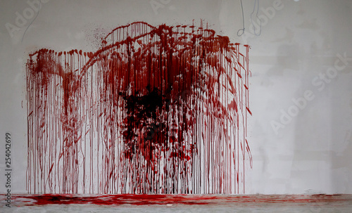 Foto Large splatter of blood on a dirty grey wall and on the floor, murder scene in a