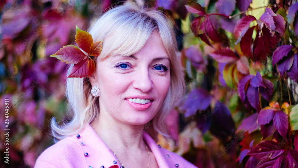 Fototapeta premium woman with a smile in a pink wool jumper with beads in spring or autumn with free space for inscriptions, signatures.