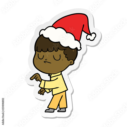 sticker cartoon of a grumpy boy wearing santa hat