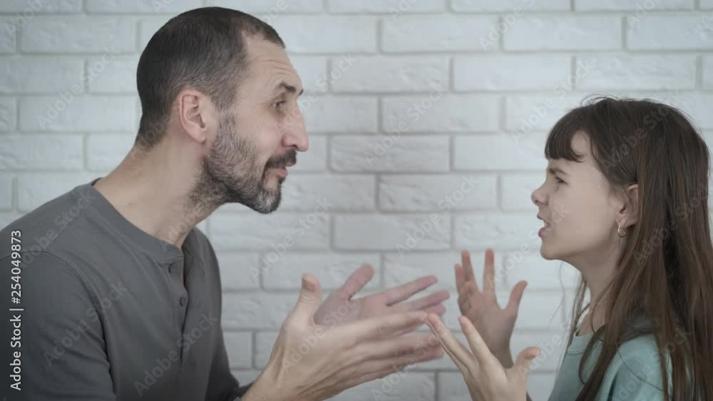 Difficult teenager. Aggression in the family. The young girl and her father are yelling at each other. Difficult teenager. Aggression in the family. The young girl and her father are yelling at each other.