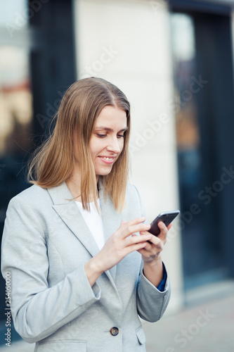 Young woman wearing casual using smartphone outdoor Free Download Young woman wearing casual using smartphone outdoor - GFXLoad