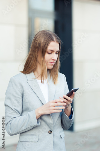 Beautiful young businesswoman using smartphone