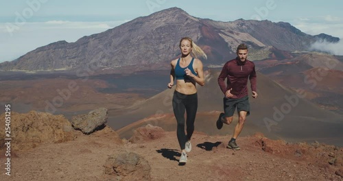 Trail running in the mountains, young athletic man and woman working out in the outdoors, running adventure lifestyle