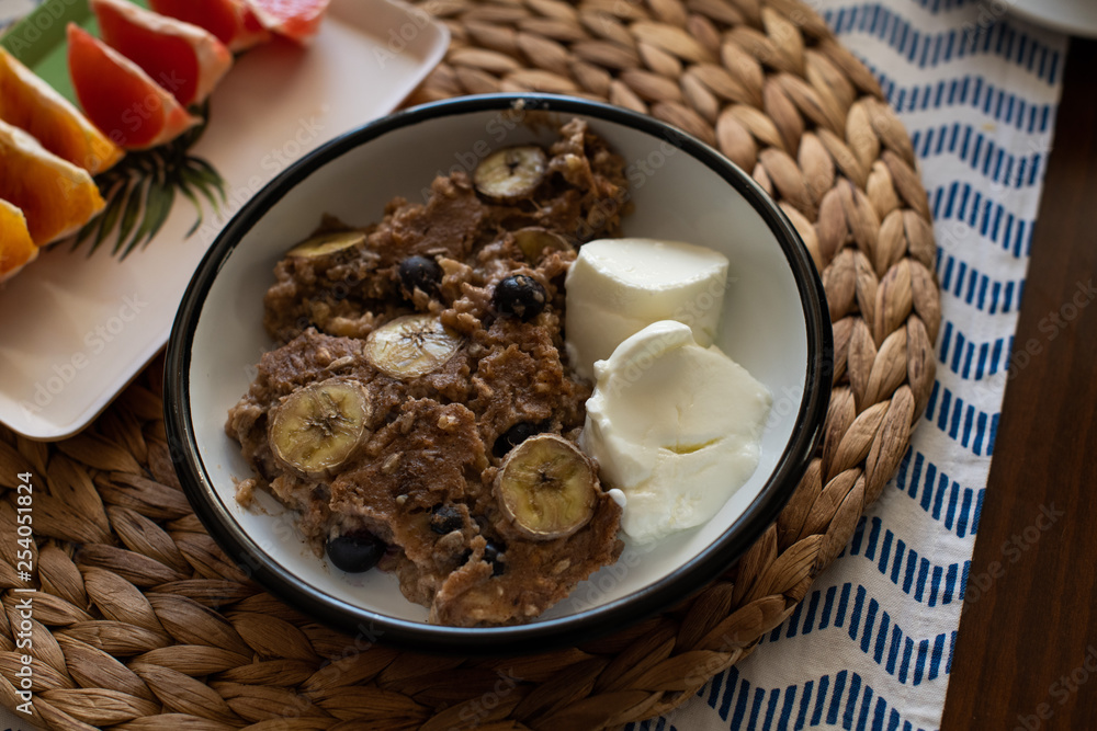 baked oatmeal with banana, blueberries, walnut and raisins. served with yoghurt baked oatmeal with banana, blueberries, walnut and raisins. served with yoghurt