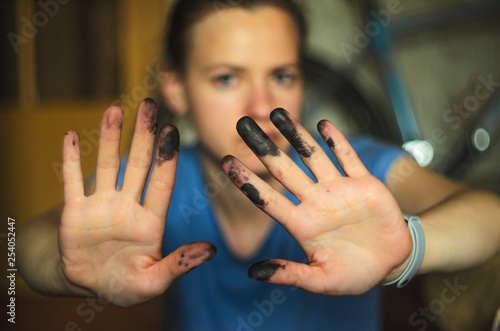 Woman shows hands soiled with black ink for printer