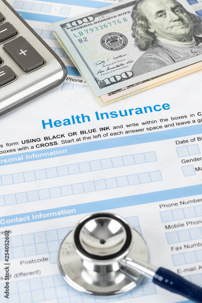 Health insurance application form with stethoscope and calculator Health insurance application form with stethoscope and calculator