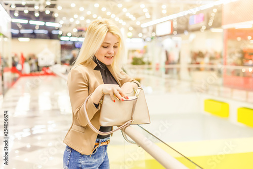 Beautiful young woman in shopping using a mobile phone
