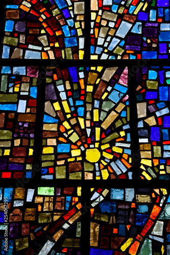 Abstract sun pattern of colors in a stained glass window mosaic in a Toronto Roman Catholic church
