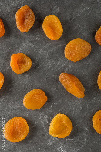 Tasty dried apricots on darck slite background photo