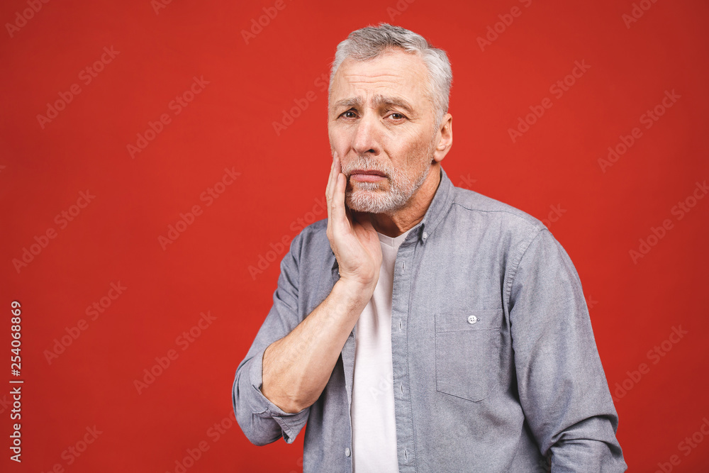 Senior aged man suffering from toothache on red background. Senior aged man suffering from toothache on red background.