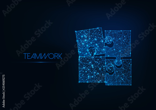 Teamwork concept with four glowing low poly jigsaw puzzle pieces on dark blue background.