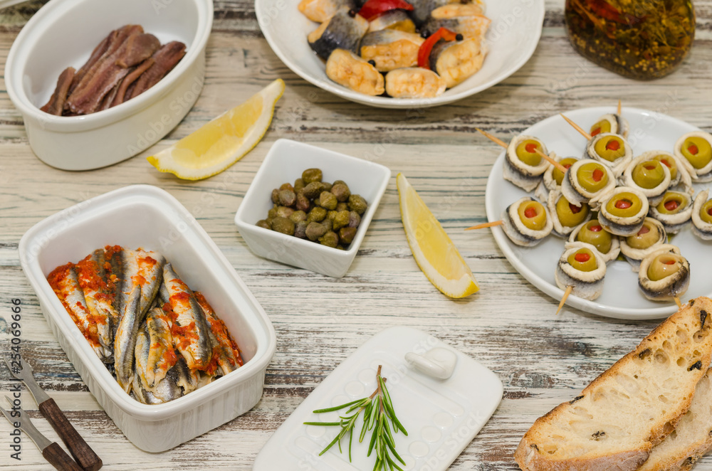 Marinated herring and anchovy fillets. Fish tapas antipasto. Rollmops