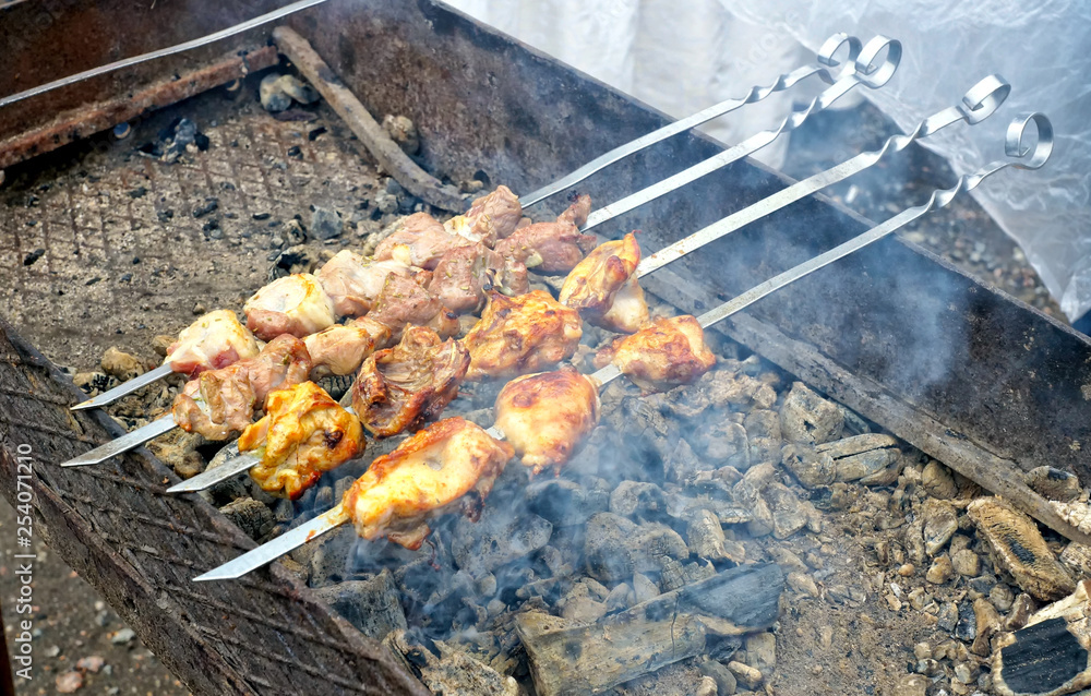 Meat on skewers, cooked on a charcoal grill on hot coals.