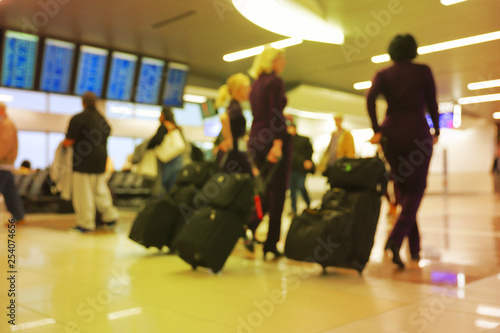 Defocus blurred bokeh of travelers in airport terminal traveling for work and vacation - abstract background © Chad Robertson