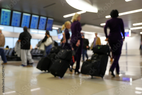 Defocus blurred bokeh of travelers in airport terminal traveling for work and vacation - abstract background