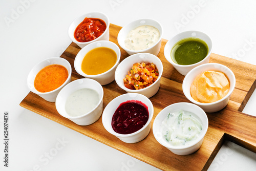 Bowls with sauces on wooden tray