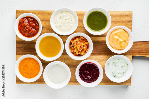 Bowls with sauces on wooden tray