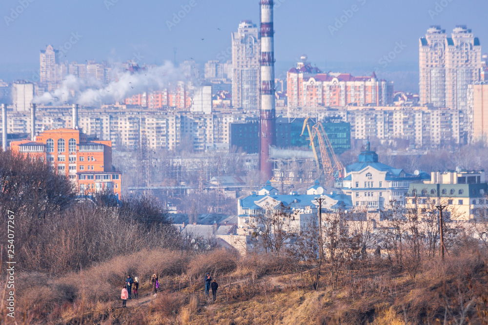 Early spring at sunny evening in warm weather. Industrial zone and residential areas Podin and northern suburbs Obolon in Kyiv on the right bank of the Dnipro River. Ukraine Mar. 6, 2019