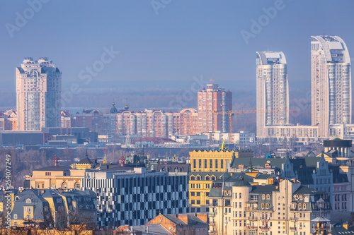 Early spring at sunny evening in warm weather. Industrial zone and residential areas Podin and northern suburbs Obolon in Kyiv on the right bank of the Dnipro River. Ukraine Mar. 6, 2019