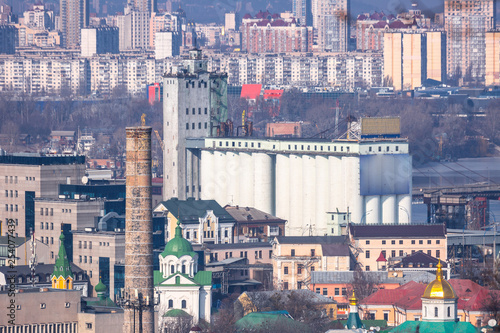 Early spring at sunny evening in warm weather. Industrial zone and residential areas Podin and northern suburbs Obolon in Kyiv on the right bank of the Dnipro River. Ukraine Mar. 6, 2019 photo