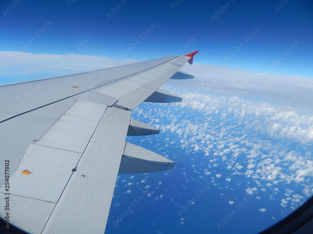 wing of airplane flying above clouds wing of airplane flying above clouds