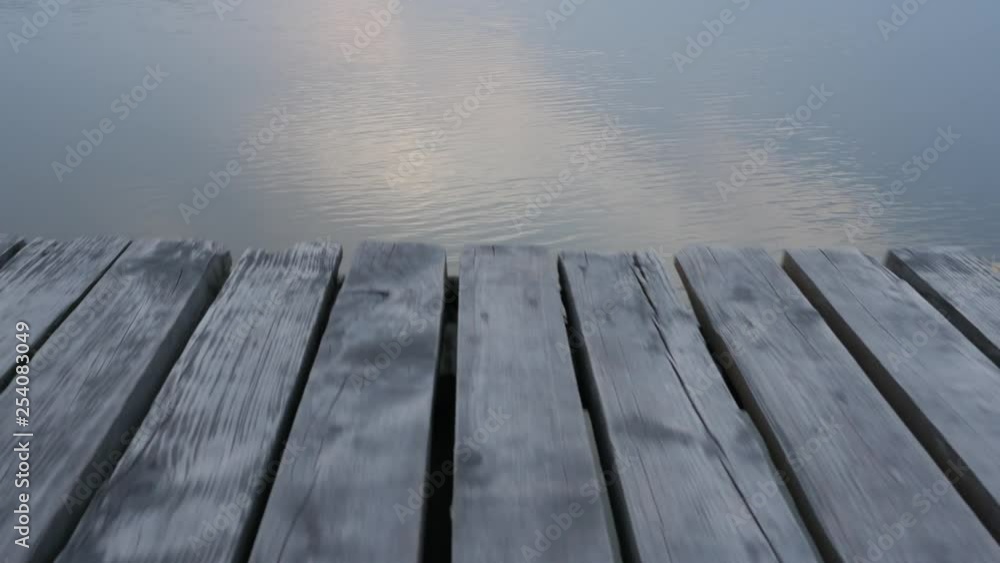 Camera moves from water on the wooden bridge. Camera moves from water on the wooden bridge.