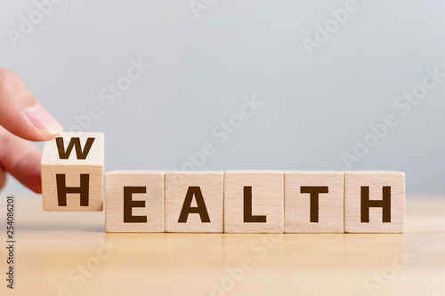 Fototapeta Naklejka Na Ścianę i Meble -  Hand flip wooden cube with word wealth to health. Investment in life insurance and healthcare concept