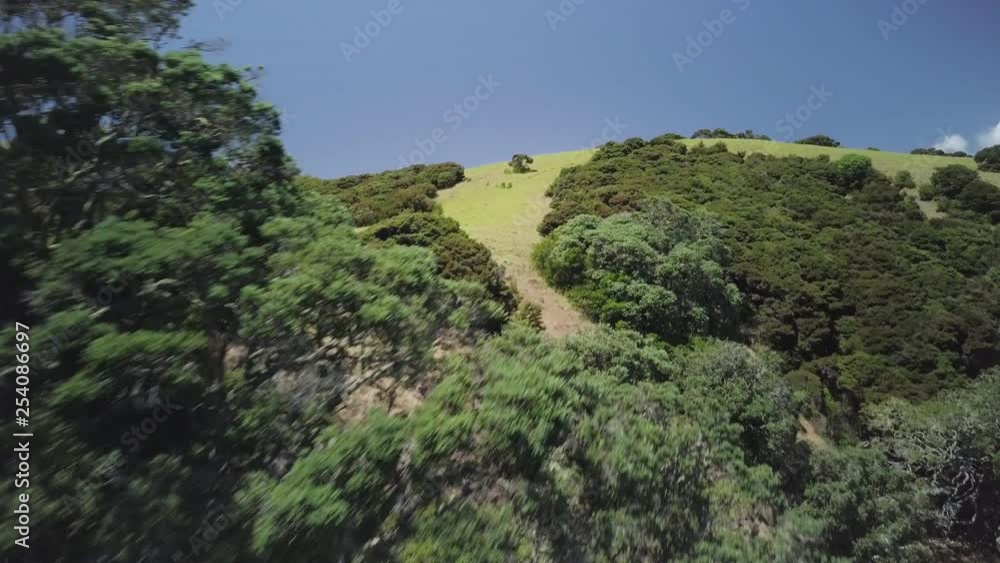 A slow moving aerial drone shot that travels up and over an island headland in a tropical paradise with white sandy beaches and crystal clear ocean water. A slow moving aerial drone shot that travels up and over an island headland in a tropical paradise with white sandy beaches and crystal clear ocean water.