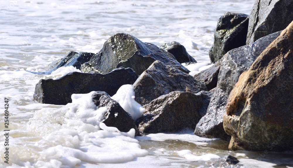 Obraz premium sea stones on the sea can be seen as a wave washes them in the summer